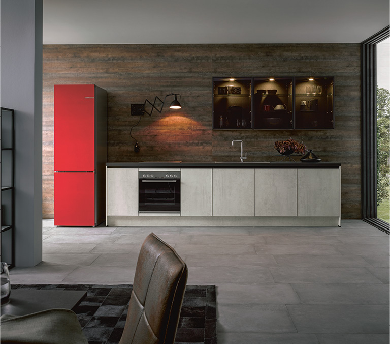 graue Küchenfront mit eingebautem Herd und Burgundfarbenem Kühlschrank