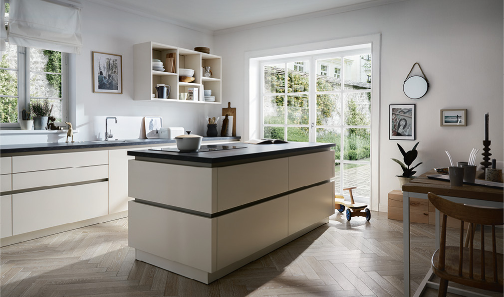 Kücheninsel mit weißen Fronten und Schwarzer Platte in Küche mit Dekor
